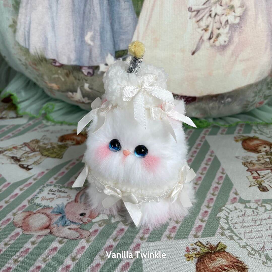 Mewlicious Collection: fluffy white kitten figurine styled as a vanilla dessert with ribbons and a pom-pom, handmade in UK.