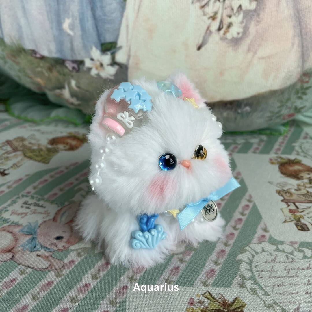 Aquarius-inspired handmade kitten plush with blue charms and ribbons, part of the Zodiac Kitten Collection.