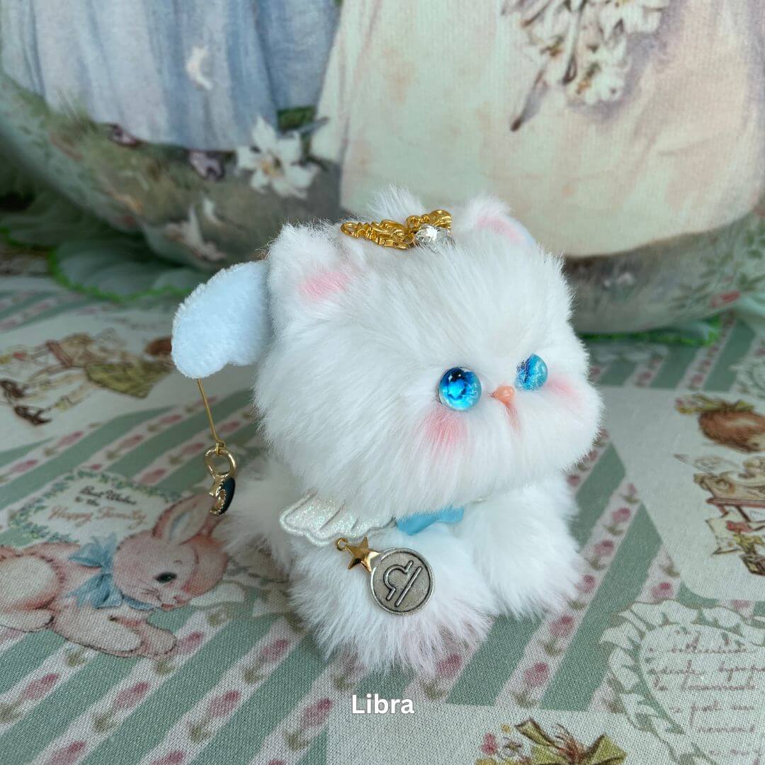 Libra zodiac kitten plush toy with angel wings, faux fur, blue eyes, and decorative charms, part of the Zodiac Kitten Collection