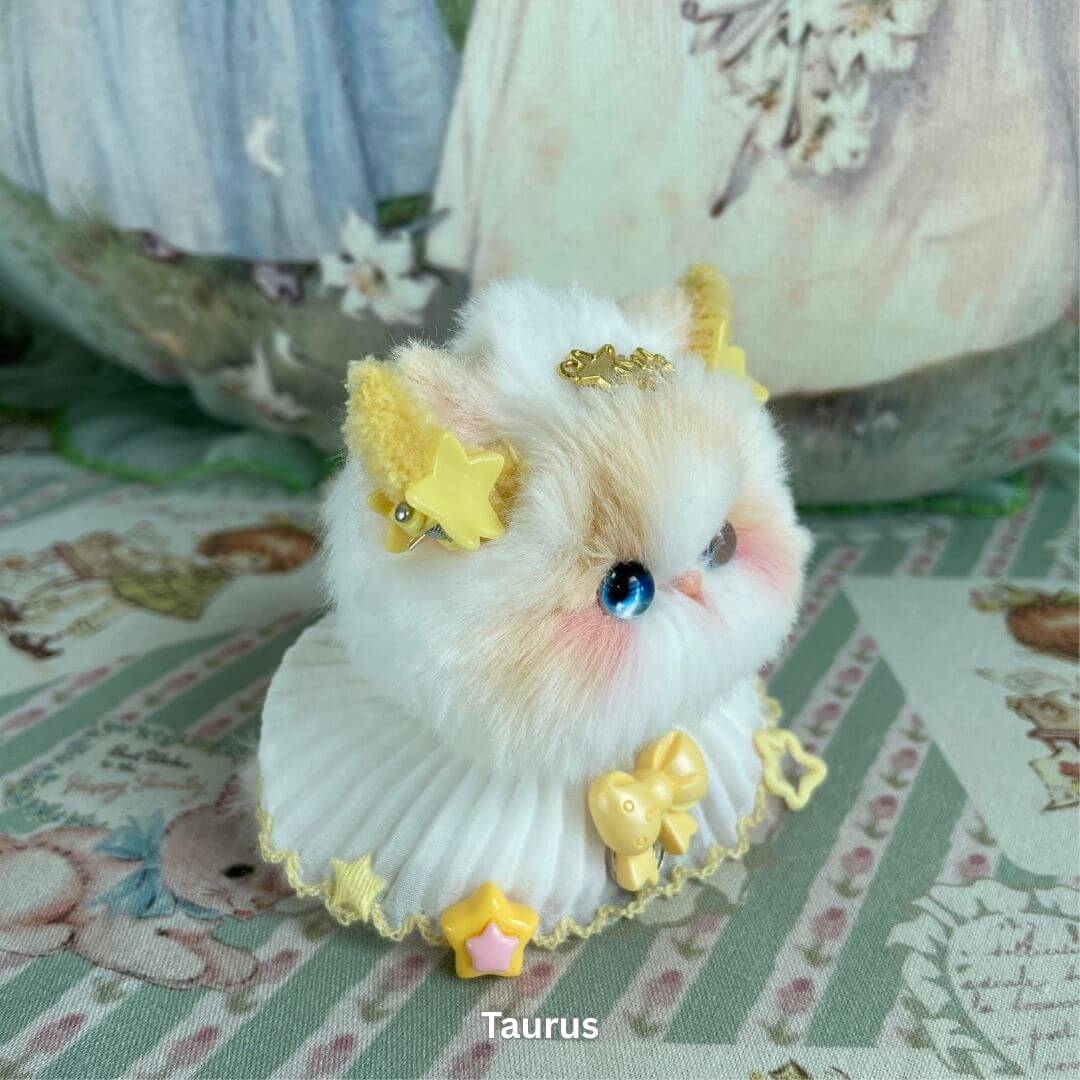 Handmade Taurus kitten plush toy with golden accessories, inspired by zodiac traits, soft faux fur, and decorative charms.